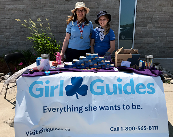 Girl and Guider selling cookies using Parade Banner